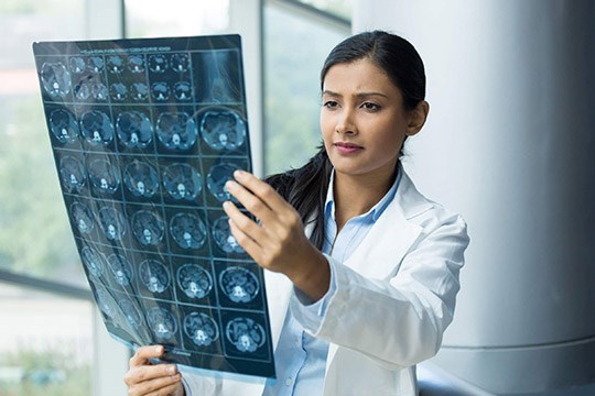 A doctor looking at brain scans.