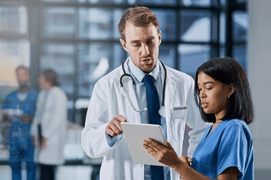 A doctor using cloud-based solutions on a tablet.
